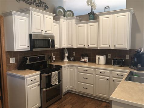 Updating oak cabinets with new hardware: Updated kitchen cabinets. Sherwin Williams Eider White ...