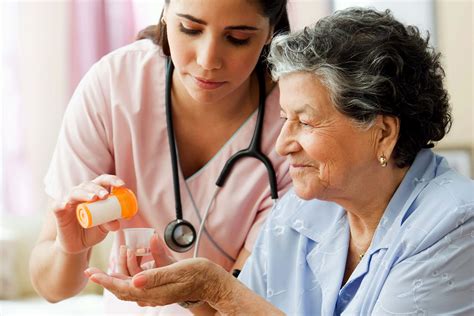 Hispanic Nurse Helping Senior Woman With Medication Preferred Home