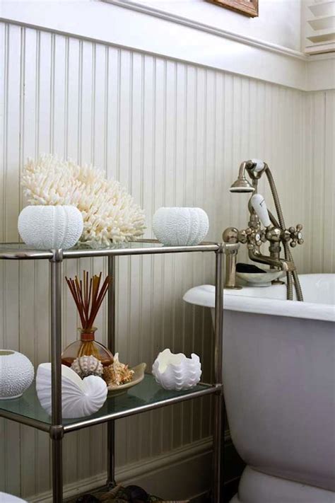 A white beadboard bath vanity sits in a light blue bathroom and is accented with a gray marble countertop fitted beneath a round pivot mirror mounted to a light gray wall lit by flower sconces. White Beadboard Bathroom - Cottage - bathroom - Old House