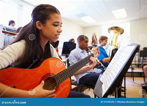 Alumno Femenino Que Toca La Guitarra En Orquesta De La High School