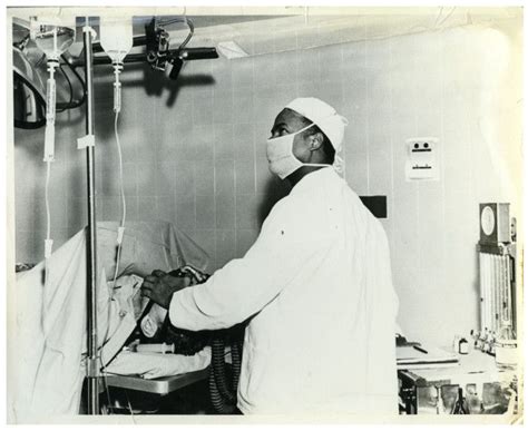 Dr. Herman Barnett garbed for surgery and looking at some ...