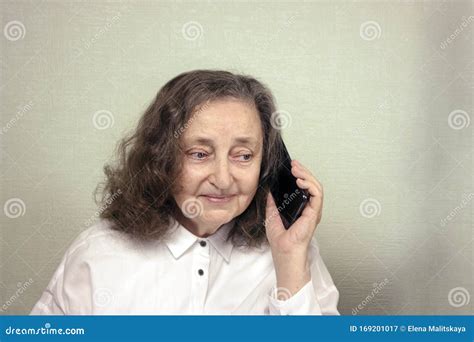 Een Mooie Oudere Vrouw Van Ongeveer 65 Jaar Is Gelukkig Met Een Mobiele Telefoon Stock