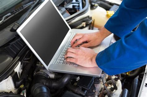 Premium Photo Mechanic Using Laptop On Car