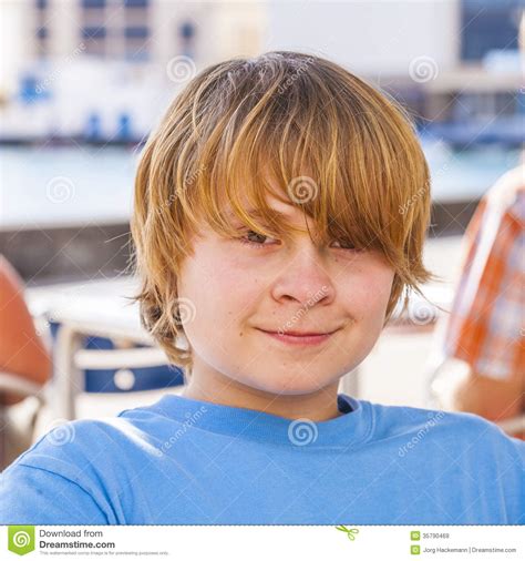 Portrait Of A Boy With Long Blonde Hair Sitting In An Open ...