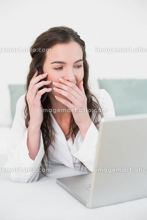 Casual Young Woman Using Cellphone And Laptop In Bed At Homeの写真素材 31729909 イメージマート