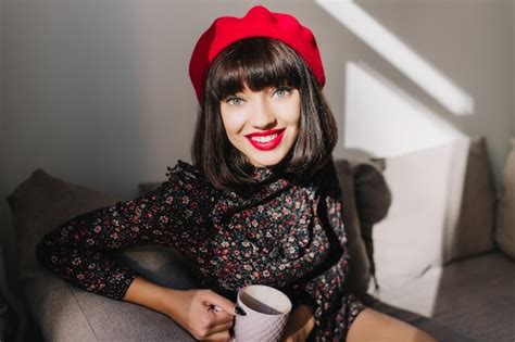 Free Photo Attractive Dark Haired Girl In Red Beret And Retro Dress Sitting In Cozy Room While