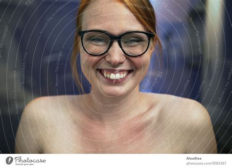 Portrait Of A Young Smiling Woman With Freckles And Glasses A