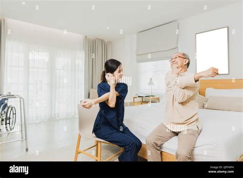 Nurse Woman Assisting Old Man Warming Up Exercises For The Upper Body