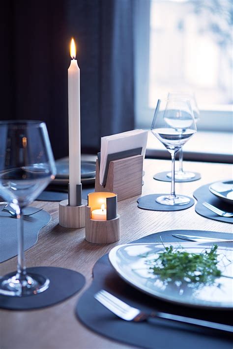 The beverage, soup and/or dessert spoons are to the right of the knife or can be brought to the table when soup or dessert is served. Restaurant table setting. Table mats and candle holders ...