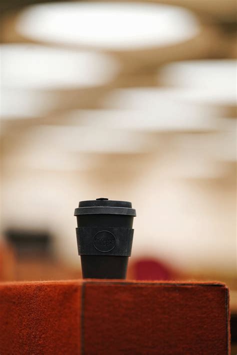 Black and Red Coffee Cup on Brown Wooden Table · Free Stock Photo