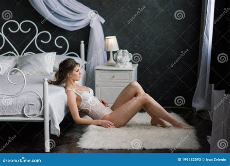 Beautiful Bride In White Lingerie Lying On The Bed In Her Bedroom Stock