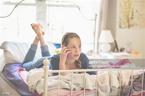 Teen Girl Laying On Bed Talking On Phone Photo Getty Images