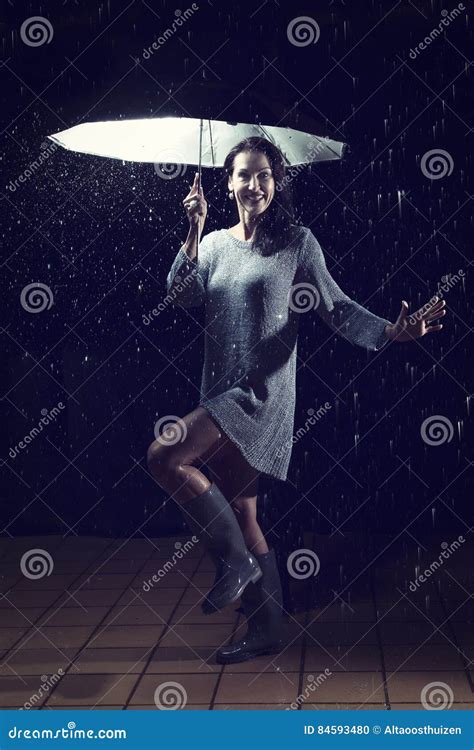 Beautiful Woman With Silver Dress Dancing In Rain Under An Umbrella At