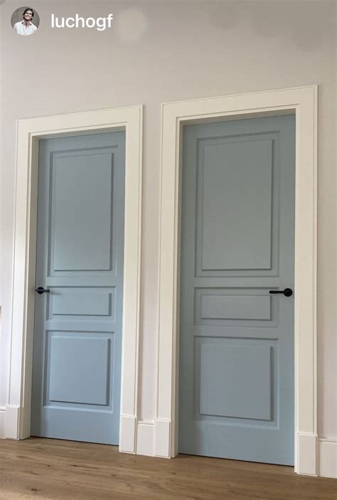 Three Blue Doors In An Empty Room With Hardwood Floors And White Walls