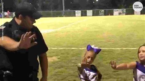 tiny cheerleaders teach police officer cheer routine during home game