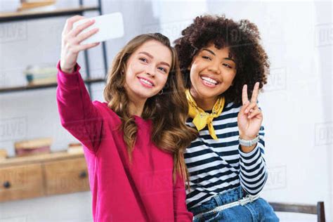 Portrait Of Cheerful Multiracial Young Women Taking Selfie Together