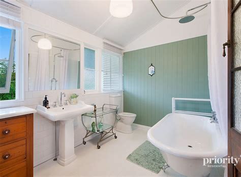 Shaker style cabinetry doors and drawers, often white in colour with light coloured stone benchtops.: Ashgrove bathroom - Queenslander Homes