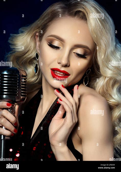 close up portrait of pretty blond female singer holding retro styled microphone beautiful