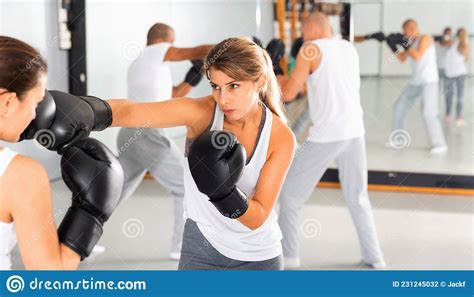 Two Women In Boxing Gloves Have Boxing Fight In The Gym Stock Photo