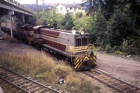 8011 And Another Baldwin Road Switcher With Empty Log Cars Near