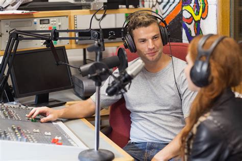 Attractive Content Radio Host Interviewing A Guest In Studio At Audio