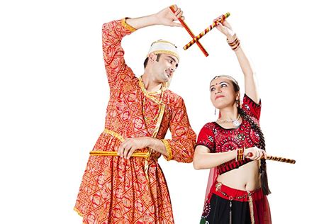 Gujarati Couple In Traditional Clothing Performing Dandiya Ras Garba On Navaratri Festival