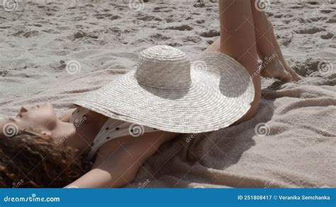 Brimmed Hat Covering Tanned Body Of Gorgeous Woman Lying Sand Beach