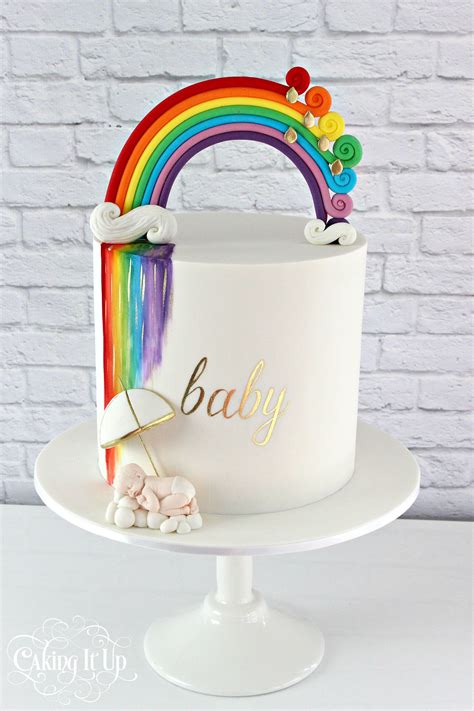 A Vibrant And Rainbow Themed Baby Shower Cake Features A Fondant