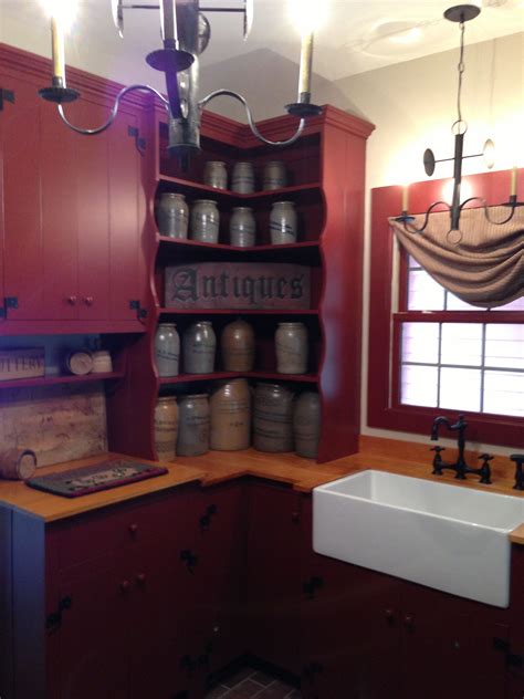 For a rustic colonial look, opt for cabinets made from knotty pine and leave them with a natural or stained finish. FARMHOUSE - INTERIOR - a primitive kitchen with a deep red ...