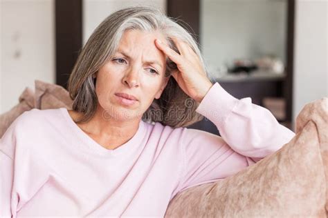Sad Pensive Middle Age Woman Looking Down Depressed Sitting On The Sofa Stock Image Image Of