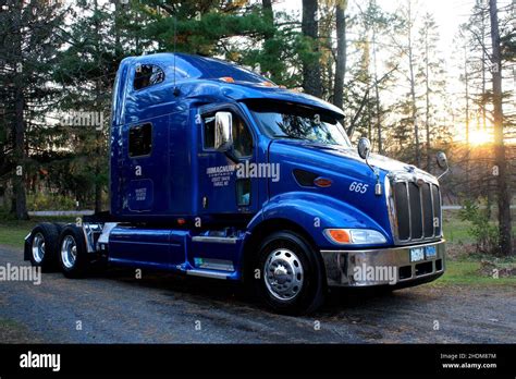 Shiny Blue Peterbilt Semi Truck With The Setting Sun In The Distance