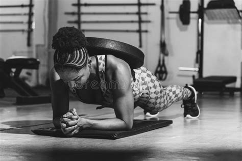 Athletic Female Fitness Enthusiast Engaging In A Weighted Planking