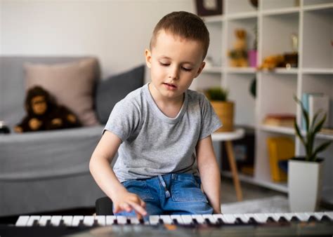 Niño aprendiendo a tocar el piano Foto Gratis