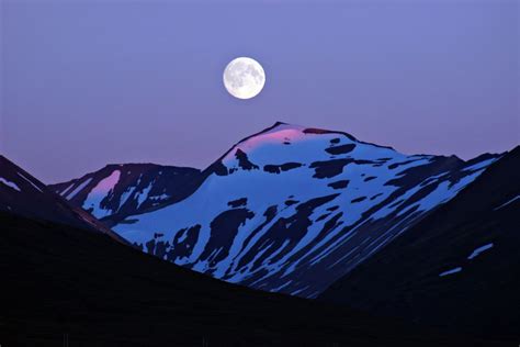 Full Moon Rising Over The Mountains On The East Coast Of Iceland