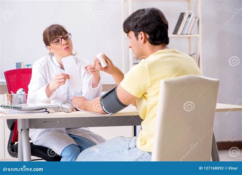 The Young Doctor Checking Patients Blood Pressure Stock Photo Image