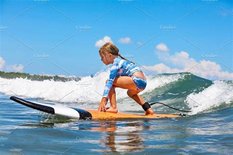 Happy Baby Girl Young Surfer Ride On Surfboard With Fun On Sea Waves