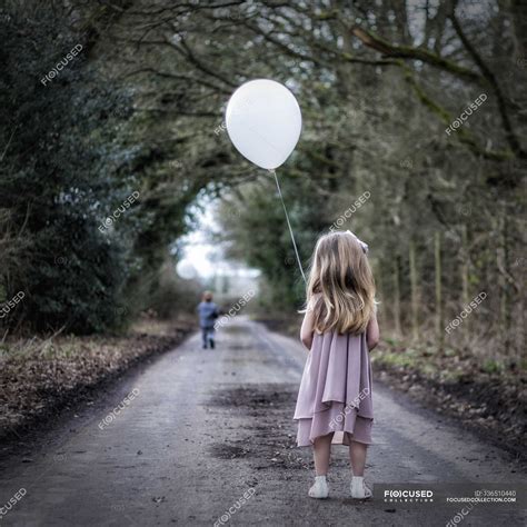 Girl Holding A Balloon — Children Only Looking Stock Photo 136510440