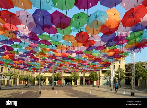 colourful parasols or umbrellas hanging above place francois villon by artist patricia cunha