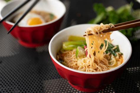 For a more formal approach, one can lay the chopstick on the ring finger rather than the middle. Free Photo | Close shot of chopsticks with noodles near the soup with blurred background