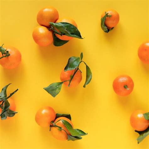 Premium Photo Orange Tangerine With Leaves On A Yellow Surface