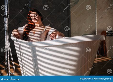 A Redhead Slender Girl In Beautiful Underwear Lies In The Bathtub In