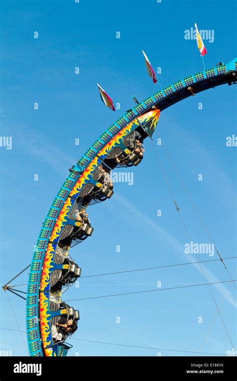 excited riders hanging upside down on a carnival ride making a loop
