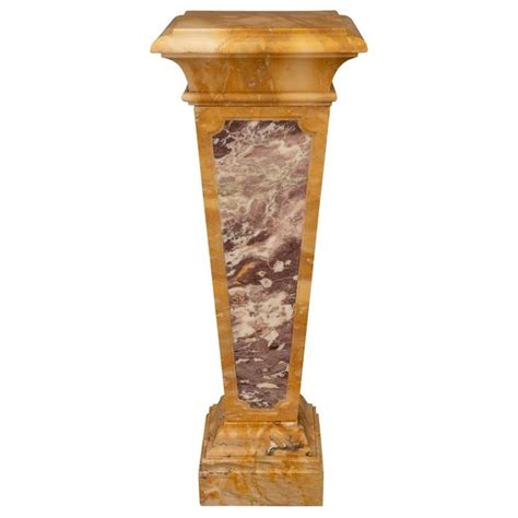 A Marble And Wood Pedestal On Display Against A White Background