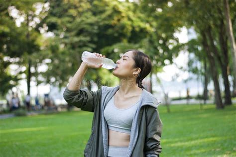 Woman Drinking Water After Exercise Is Done In The Park Stock Image