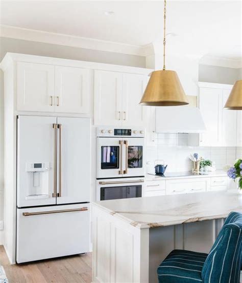 When it comes to kitchen design, knotty pine cabinets or paneling often get a bad rap for being dated and overpowering in a small space. GE Appliances Cafe appliances in matte-white #whitekitchen ...