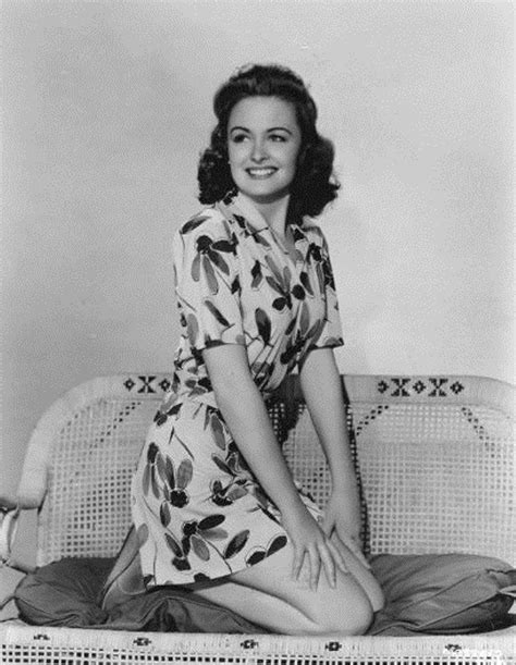 An Old Black And White Photo Of A Woman Sitting On A Couch
