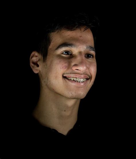 Portrait Of Smiling Mixed Race Teenage Boy On Black Background Stock