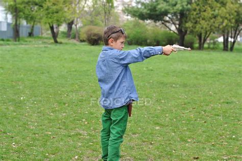 Boy Playing With A Toy Gun On Lawn — Aiming People Stock Photo