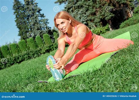Healthy Lifestyle Woman Practicing Yoga On Mat Outdoors Sitting Stretching Leg Looking Forward