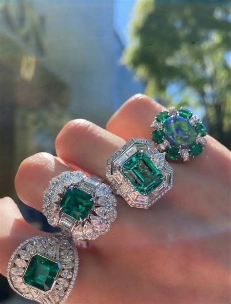 Three Emerald And Diamond Rings On Someone S Hand